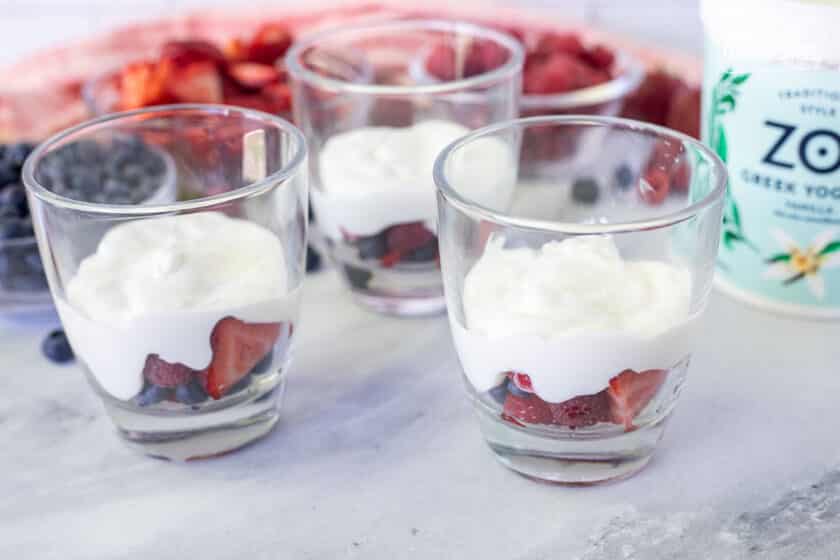 Three glasses with layers of fruit and yogurt for Breakfast Parfaits.