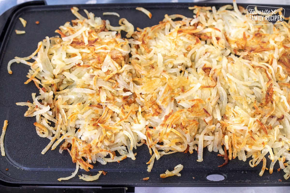 Cooked golden Hash Browns made on the griddle.