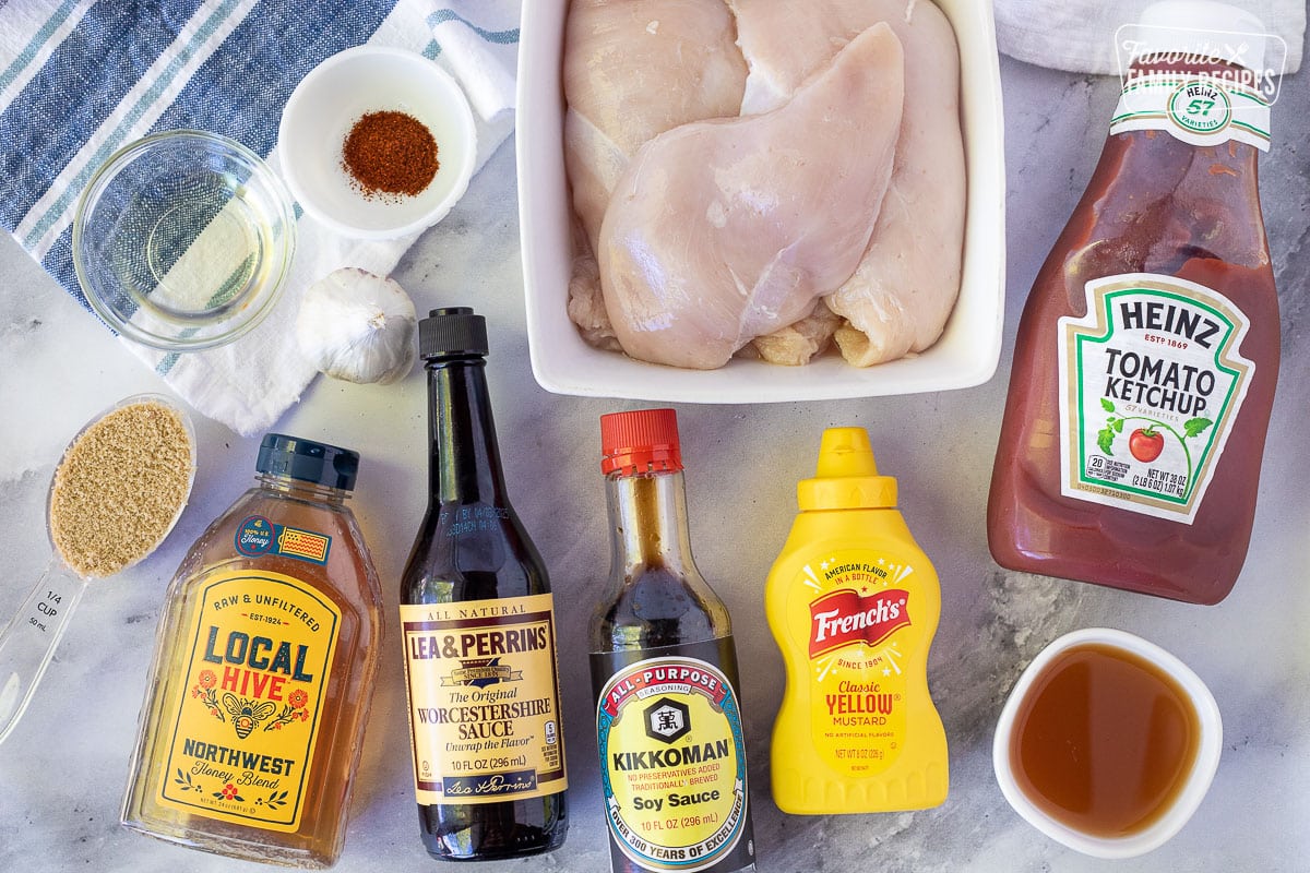 Ingredients to make Honey BBQ Chicken including ketchup, chicken breasts, oil, chili powder, brown sugar, garlic, honey, Worcestershire sauce, soy sauce, yellow mustard and apple cider vinegar.