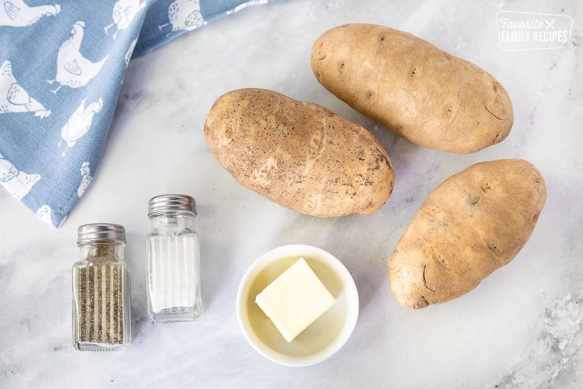 Ingredients to make Hash Browns including large russet potatoes, butter, salt and pepper.