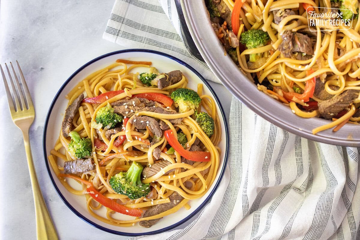 Plate of Beef Stir Fry next to skillet of Beef Stir Fry.