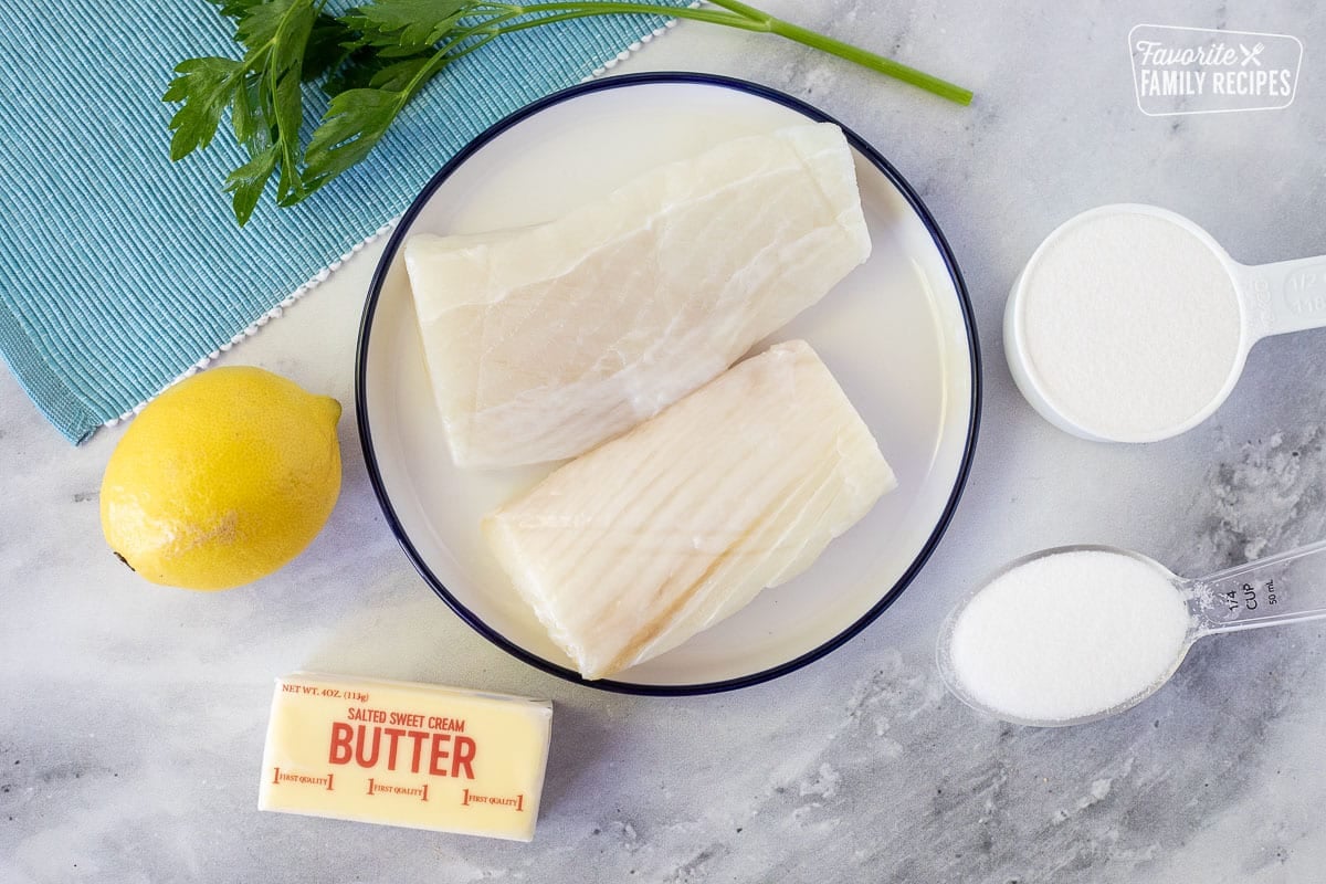 Ingredients to make Poor Man's Lobster including raw halibut, lemon, butter, salt and sugar.