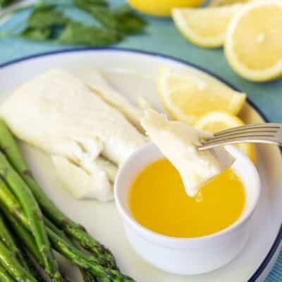 Piece of Poor Man's Lobster dripping in butter on a fork.
