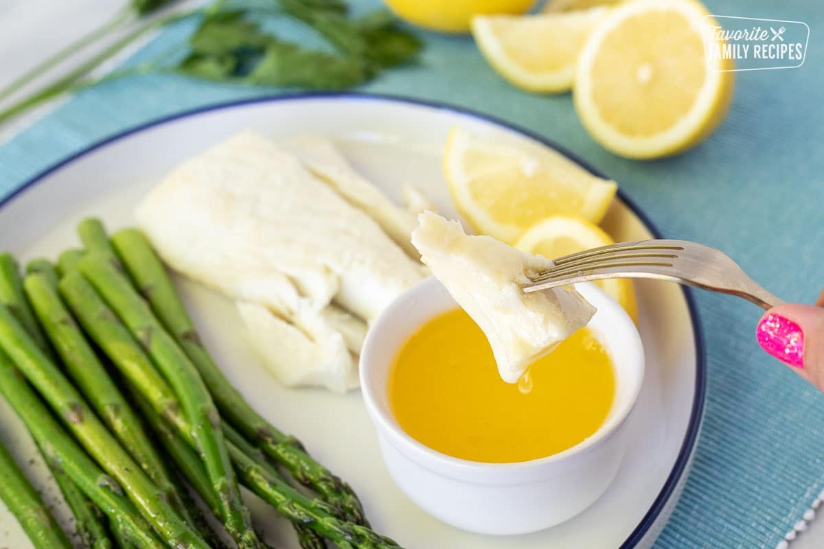 Piece of Poor Man's Lobster dripping in butter on a fork.