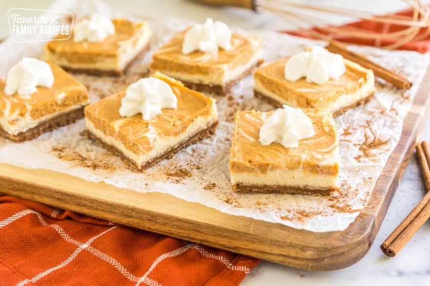 Pumpkin Cheesecake Bars topped with whipped cream.