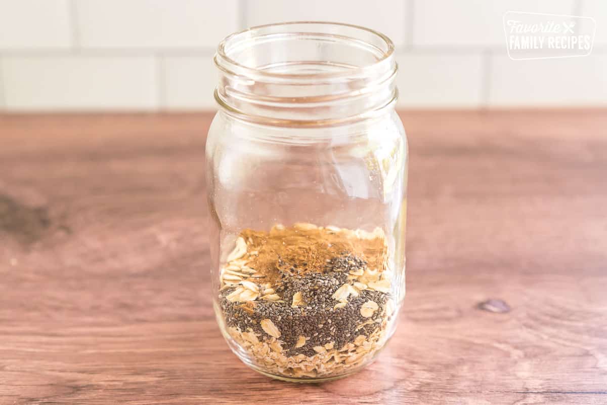 Oats, chia seeds, and pumpkin pie spice in a mason jar.