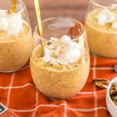 Pumpkin overnight oats in a cup with whipped cream.