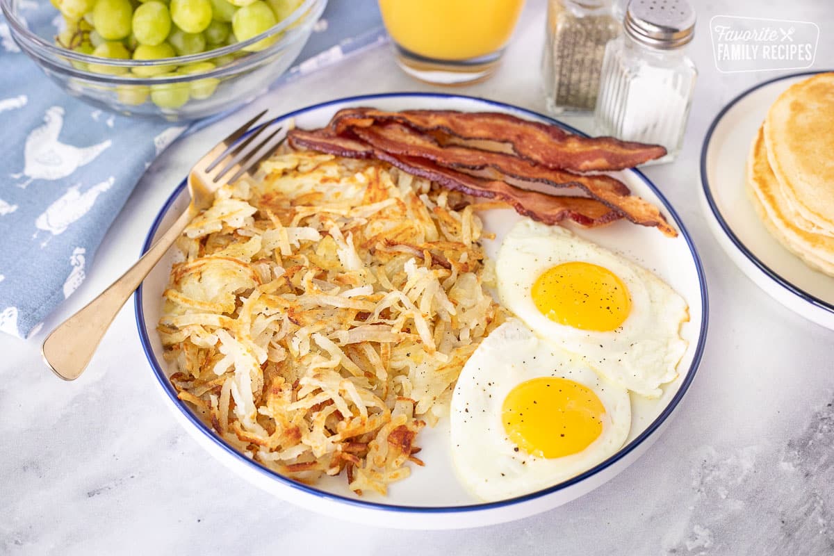 Plate of fresh made Hash Browns, eggs and bacon.