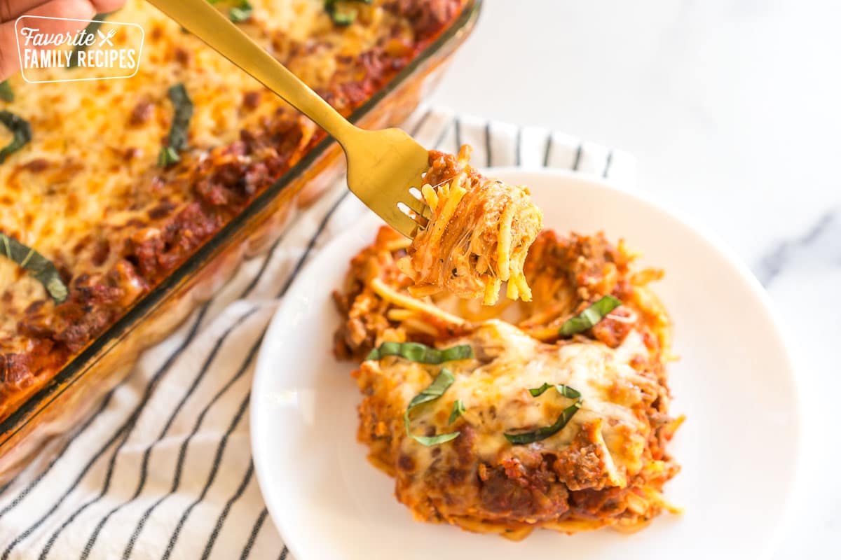 A forkful of spaghetti casserole on a gold fork.