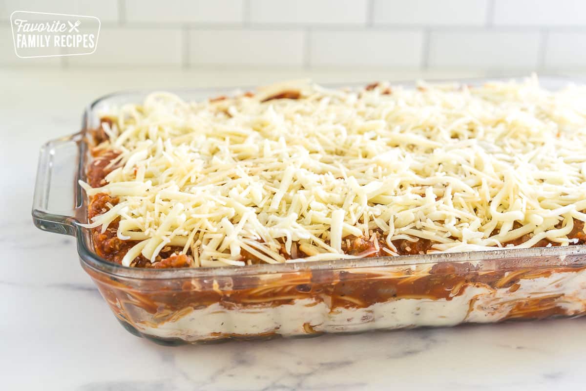 Layers of pasta, cheese, and meat sauce in a glass baking dish.