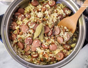Brazilian Rice and Beans in a skillet with a wooden spoon.