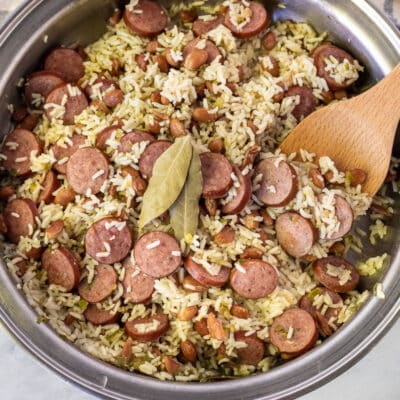 Brazilian Rice and Beans in a skillet with a wooden spoon.