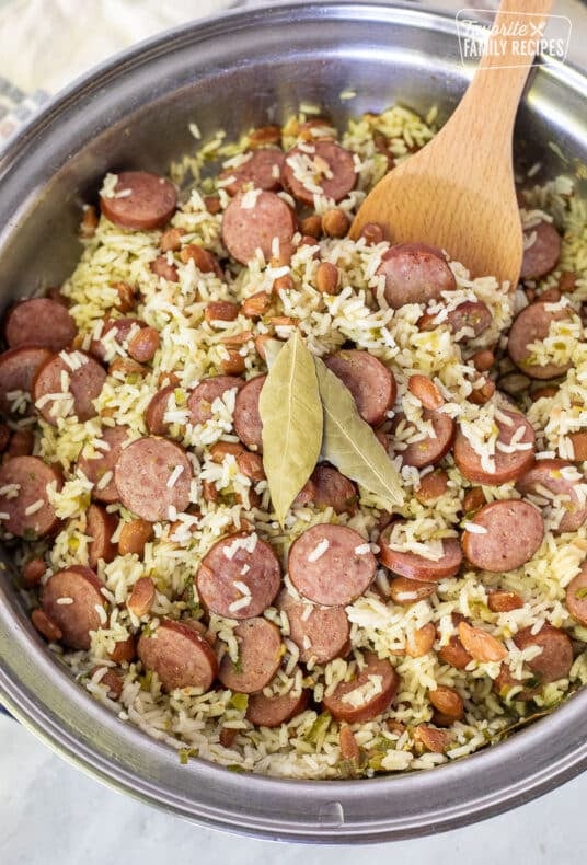 Brazilian Rice and Beans in a skillet with a wooden spoon.