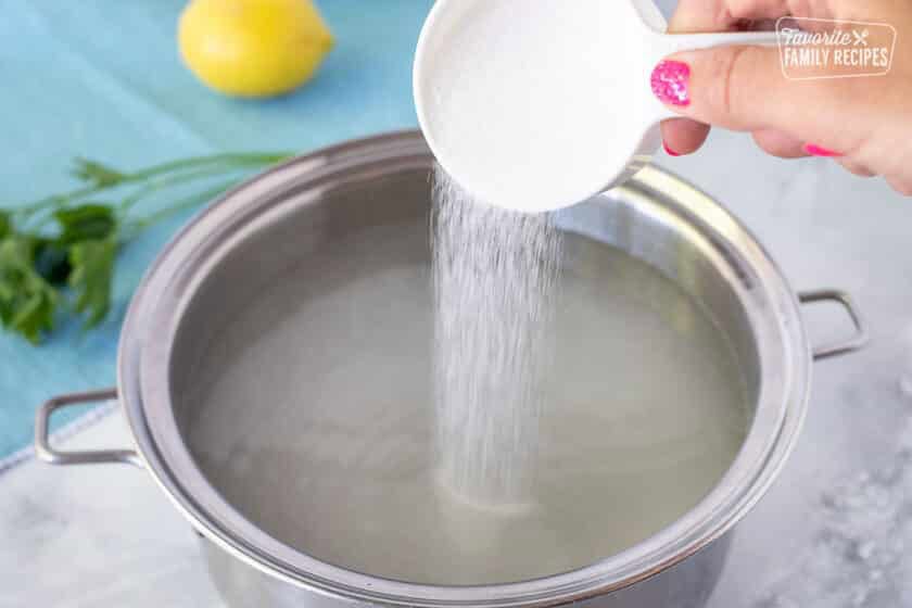 Pouring sugar into a pan of water for Poor Man's Lobster.