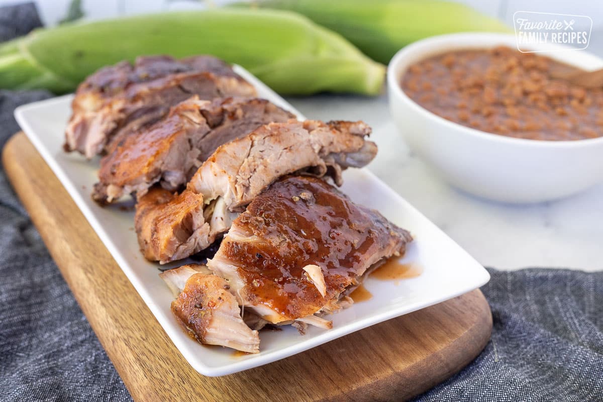 Serving tray of Crock Pot Ribs cut into sections.