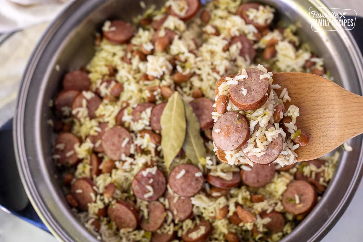 Wooden spoon holding up Brazilian Rice and Beans.