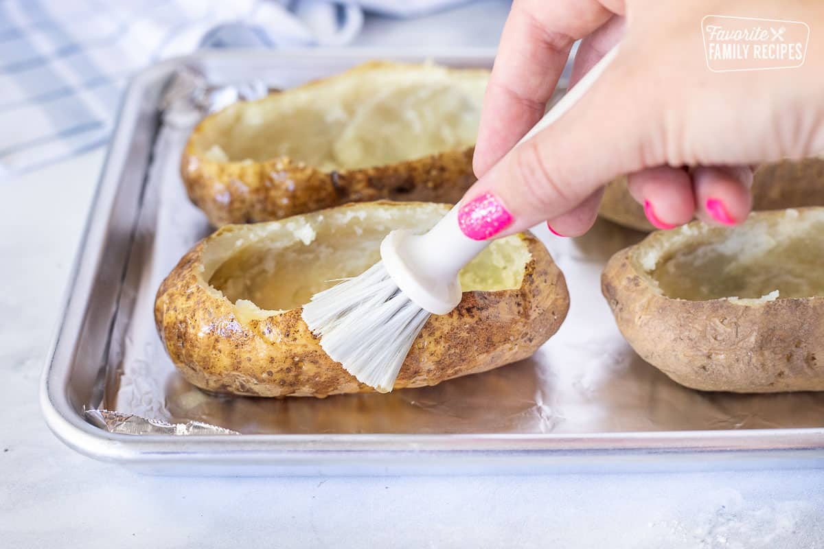 Brushing butter on a potato skin for Twice Baked Potatoes.