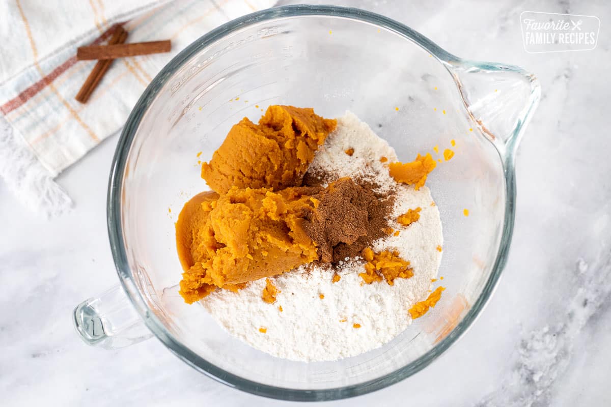 Mixing bowl with yellow cake mix, pumpkin and pumpkin pie spice for Pumpkin Poke Cake.