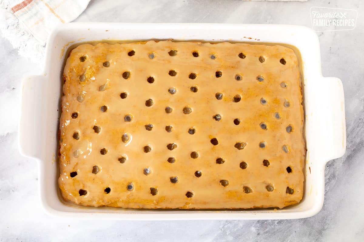 Caramel milk mixture covering the top of the Pumpkin Poke Cake.