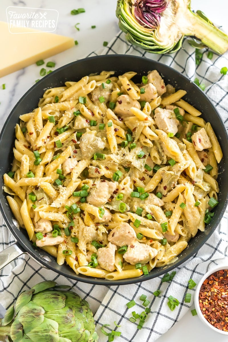 This Chicken Artichoke Pasta can be prepared and ready to eat in 30 minutes. You will love the tender chicken, flavorful artichokes, and creamy sauce. Chicken Artichoke Pasta in a skillet.