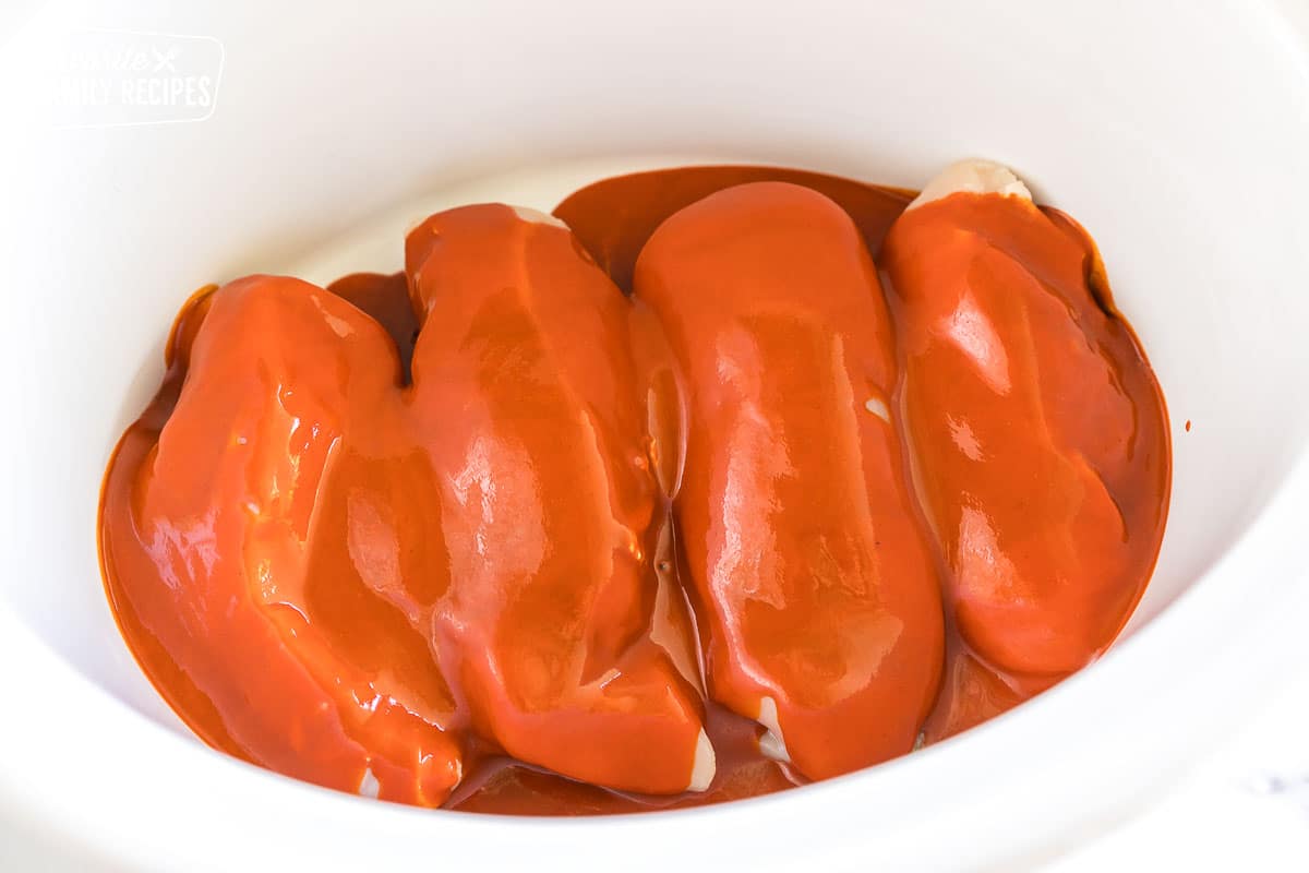 Chicken covered with hot sauce in a crock pot