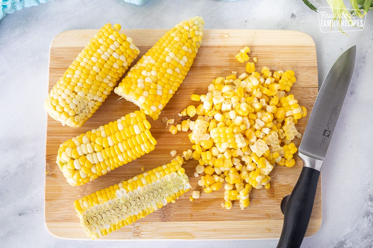 Cutting board with knife and cut corn kernels from the cob for Fresh Corn Salsa.