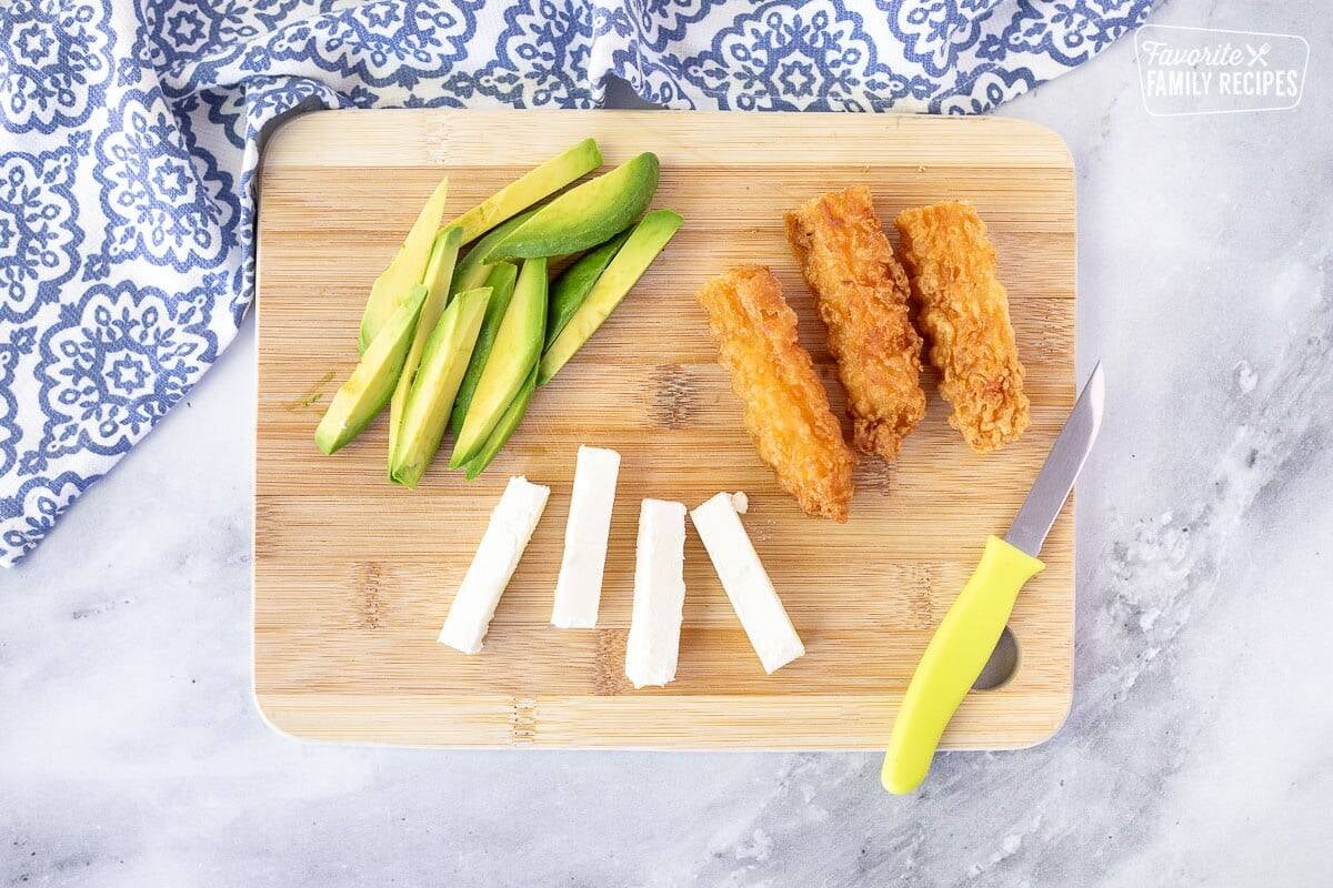 Cut up avocado, shrimp tempura and cream cheese for a Shrimp Tempura Roll.