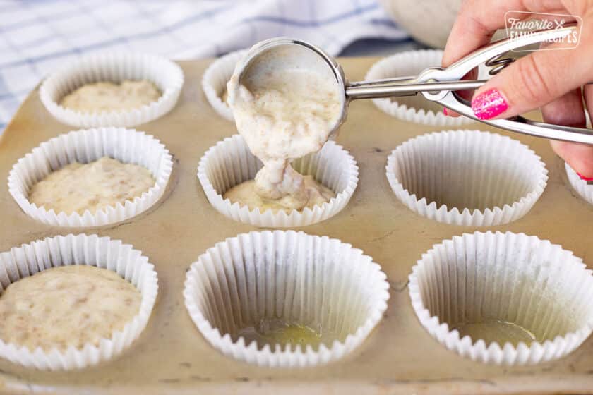 Filling muffin cups with a cookie scoop of Bran Muffin batter.