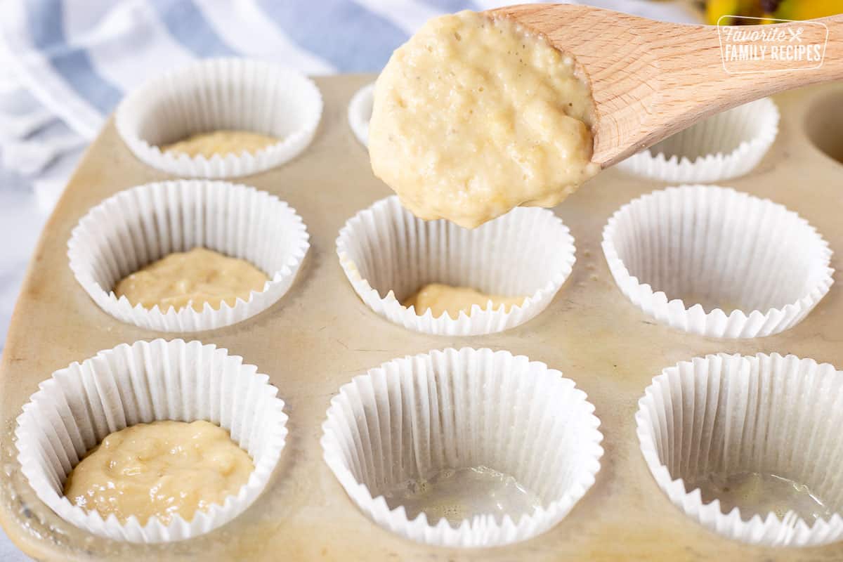 Spooning Healthy Banana Muffin batter into cupcake liners.