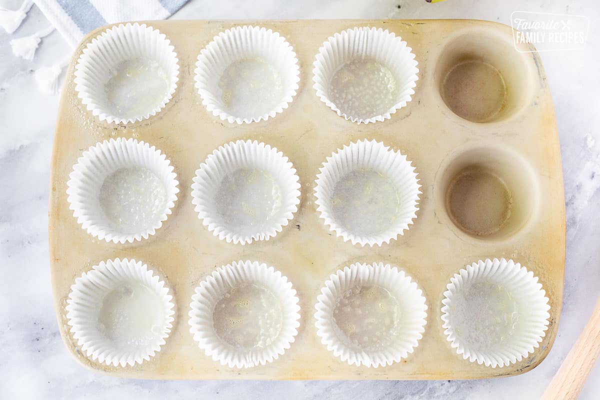 Cupcake pan with greased liners for Healthy Banana Muffins.
