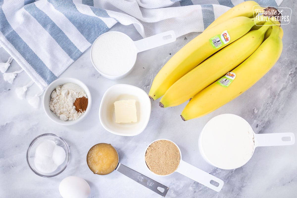 Ingredients to make Healthy Banana Muffins including bananas, flour, sugar, cinnamon, butter, applesauce, egg, brown sugar, baking soda, baking powder and salt.