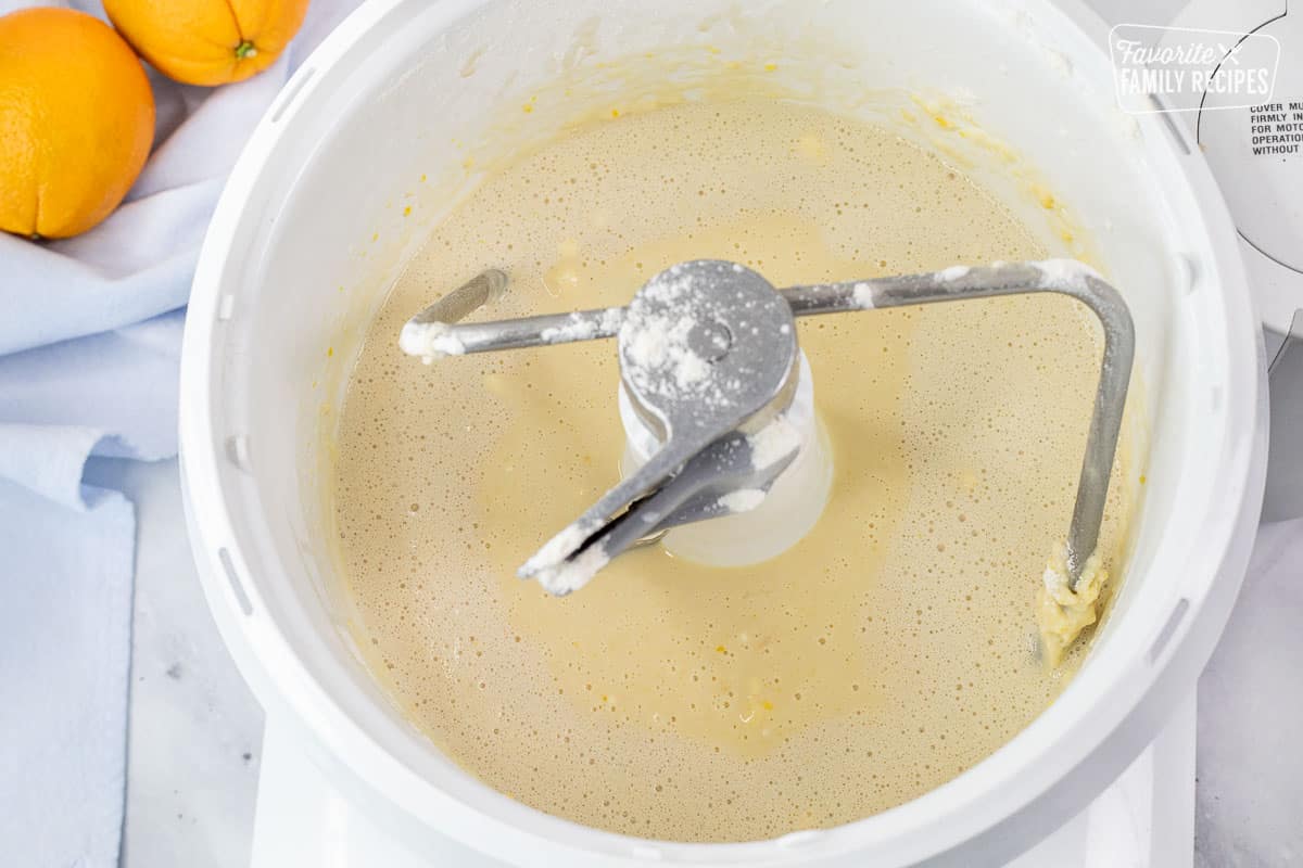 Mixer with eggs, salt, yeast mixture and milk for Homemade Orange Rolls.