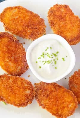 Platter of Parmesan Crusted Potatoes with a dish of sour cream and chives.