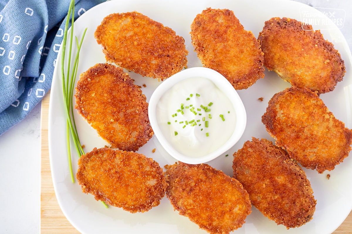 Platter of Parmesan Crusted Potatoes with a dish of sour cream and chives.
