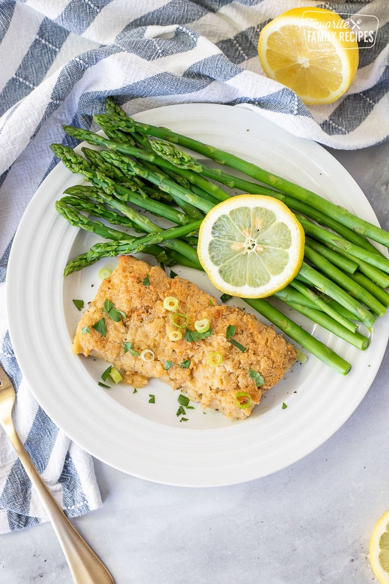 Plate of asparagus with a fillet of Baked Mahi Mahi with Parmesan Crust.