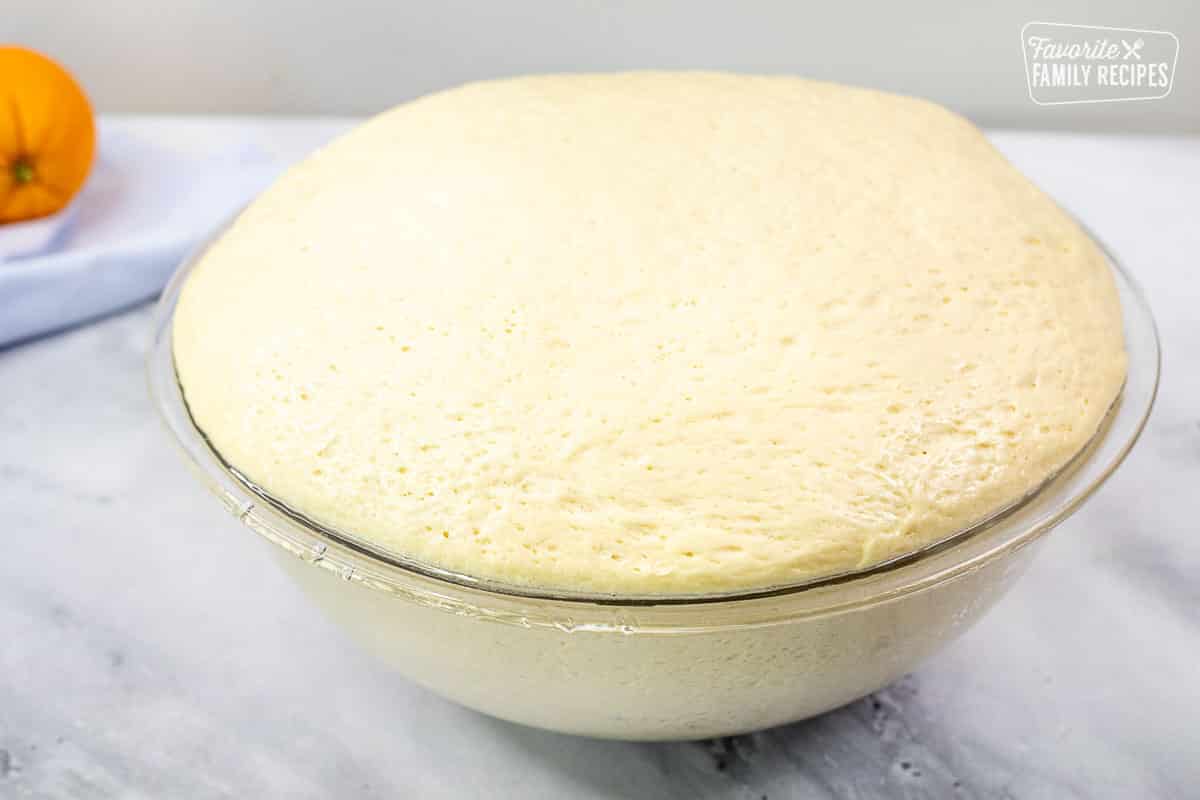 Bowl with risen dough for Homemade Orange Rolls.