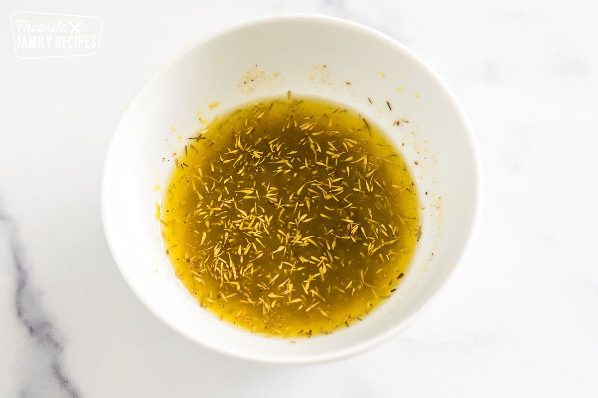 melted butter, olive oil, honey, garlic powder, thyme, lemon zest, salt, and pepper mixed together in a bowl