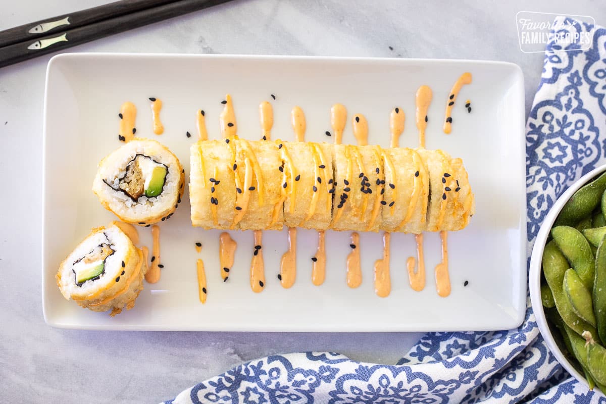 Shrimp Tempura Roll drizzled with spicy mayo and black sesame seeds.