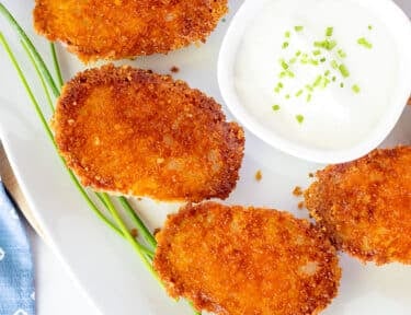 Platter of Parmesan Crusted Potatoes with sour cream.