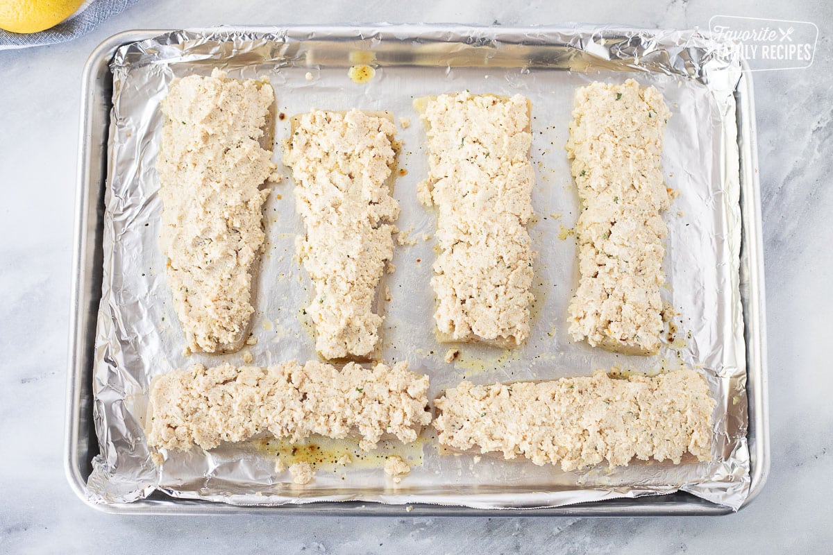 Baking pan lined with foil with six Mahi Mahi fillets with parmesan crust topping.