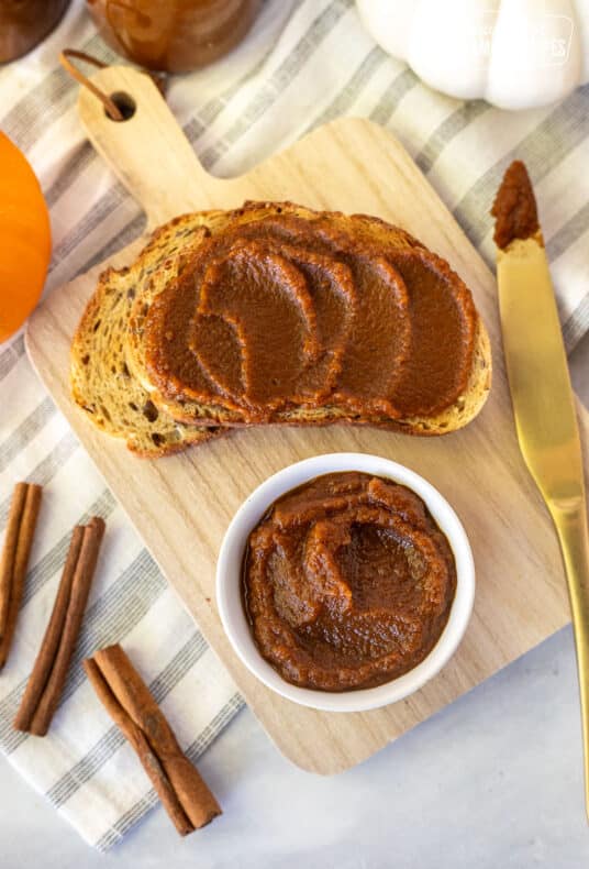 Small bowl of Pumpkin Butter on a cutting board with toasted bread.