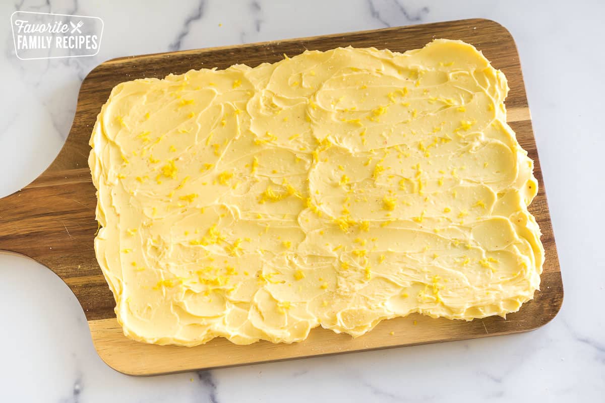 butter smeared on a wooden slab topped with lemon zest and salt
