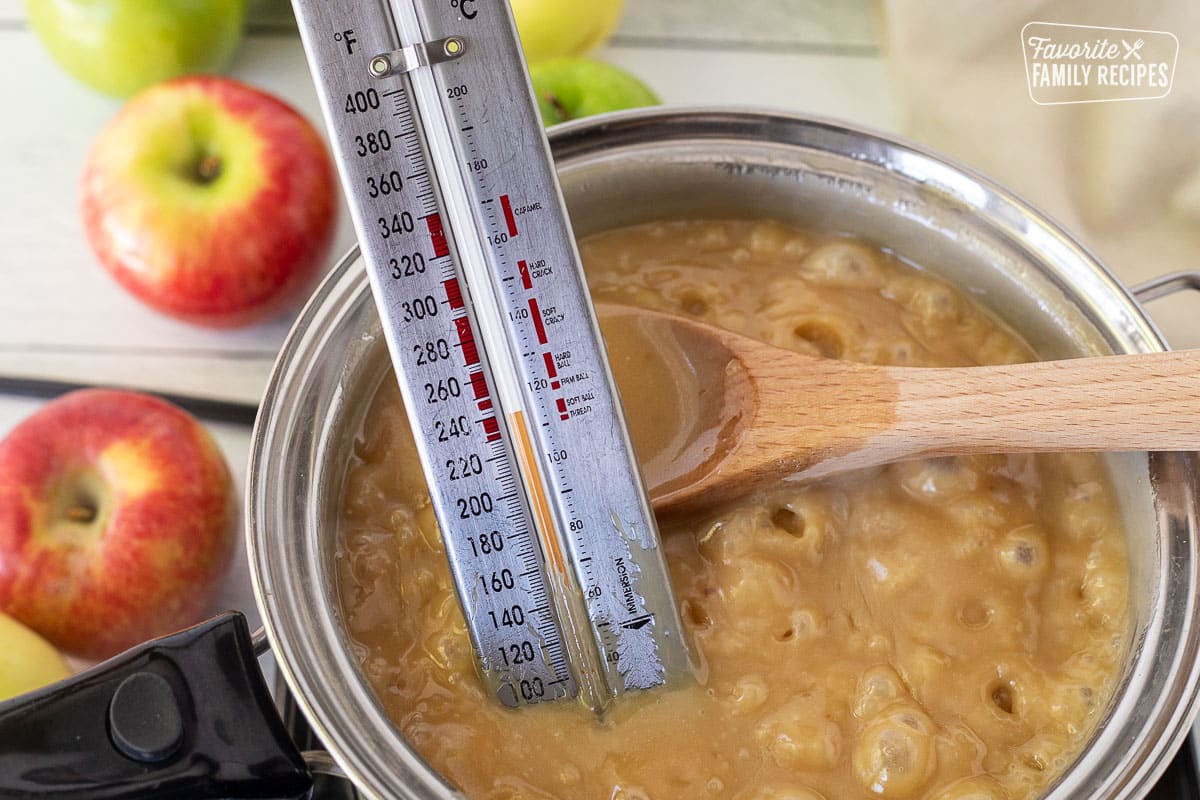 Candy thermometer in a pan of boiling Caramel Apple Dip.