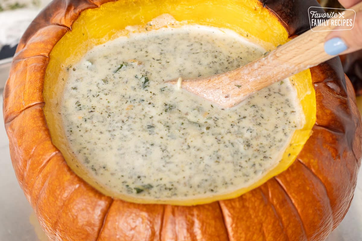 Stirring cream into Soup in a Pumpkin.