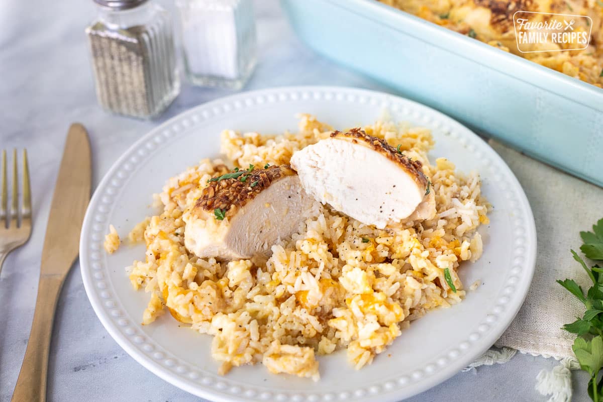 Plate with Cheesy Chicken and Rice Casserole and chicken cut in half.