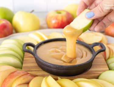 Dipping a green apple slice into a dish of Caramel Dip.
