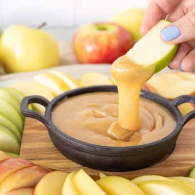 Dipping a green apple slice into a dish of Caramel Dip.
