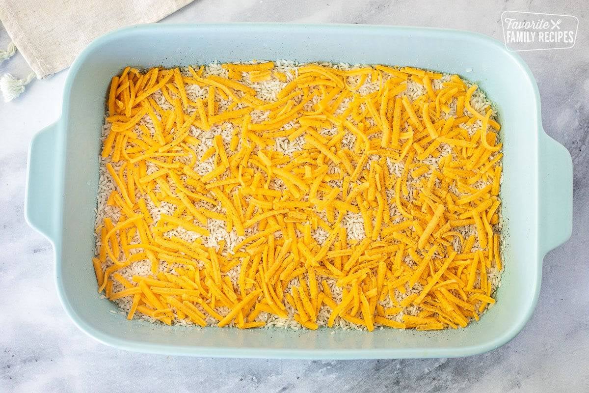 Casserole dish with rice and cheese for Cheesy Chicken and Rice Casserole.