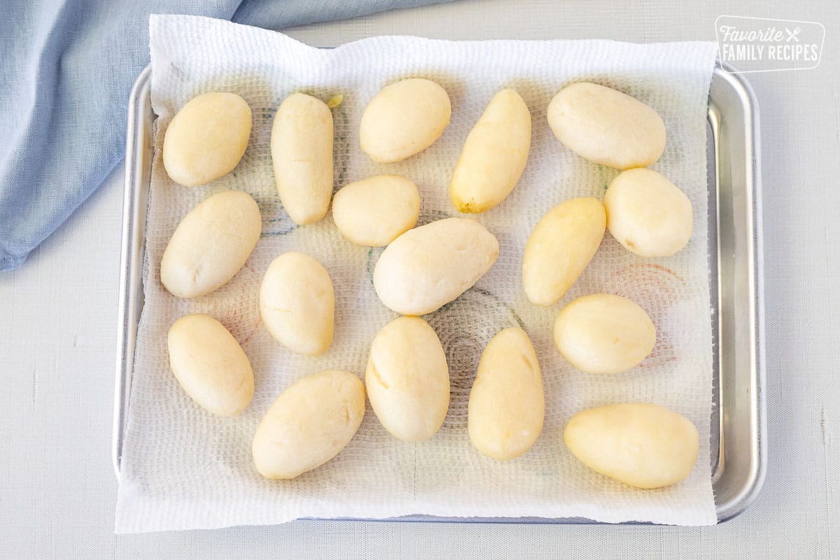 Baking sheet with small potatoes drying on a paper towel for Brunede Kartofler.