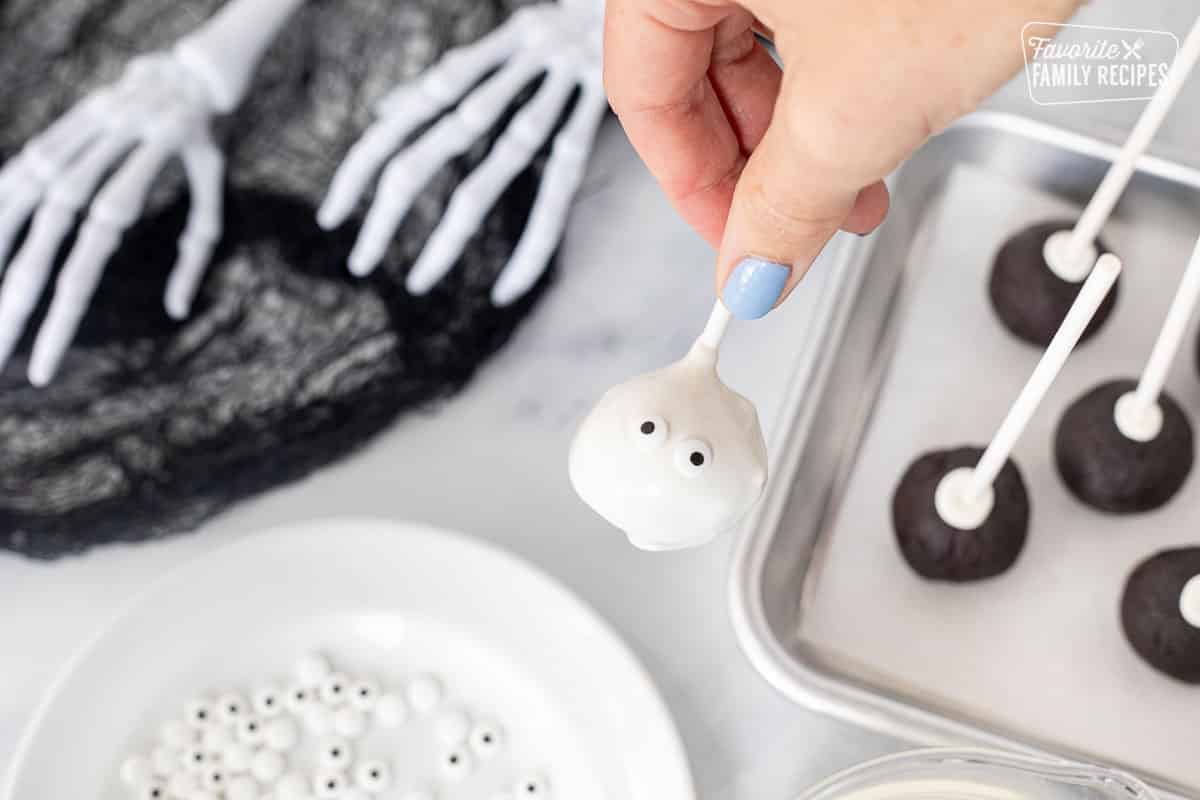 White cake pop covered with candy melts and two candy eyeballs for a mummy Halloween cake pop.